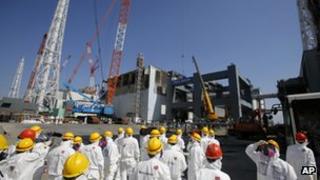 Journalists inspect damaged No.4 reactor building at Fukushima Daiichi nuclear power plant