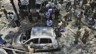 Police and forensic officials inspect the scene of a blast near the office of India"s main opposition Bharatiya Janata Party (BJP) in the southern Indian city of Bangalore April 17, 2013.
