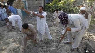 Earthquake survivors work on the rubble of a mud house after it collapsed following the quake in Jalalabad province, 24 April 2013