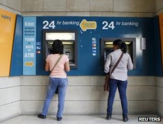 Women withdraw cash from machines in Nicosia, Cyprus, 30 April