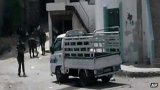 Citizen journalist image provided by activists to AP purporting to show Syrian soldiers at the scene of a killing in al-Bayda, near Baniyas, 2 May 2013