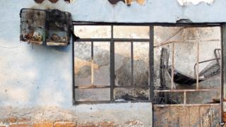A burned out birdcage hangs from a wall outside a house in Ecatepec in Mexico on 7 May 2013