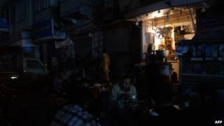 Pakistani people drinking tea outside a restaurant during a nationwide power blackout in Karachi