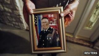Wilburn Russell, 73, displays a portrait of his son, Sergeant John M. Russell, the Army sergeant who is accused of killing five fellow soldiers in Iraq, outside of his sons home in Sherman, Texas 12 May 2009