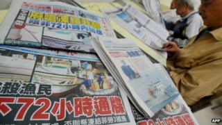 Newspapers show headlines carrying the story of a Taiwanese fisherman shot by Filipino coastguards, at a library in New Taipei City on May 12, 2013.