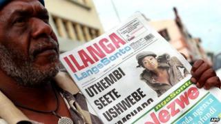 A man holds a copy of a Zulu language newspaper in Durban, South Africa (20 March 2011)