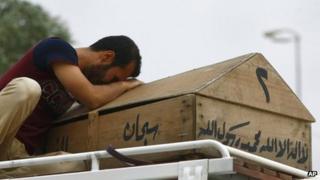 A man weeps over his daughter's coffin in the city of Najaf , 20 May