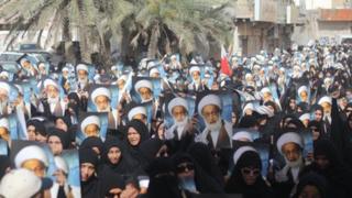 Protesters carrying images of Sheikh Isa Qassim walk in Diraz 24 May 2013