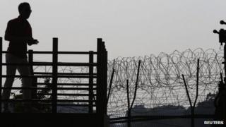 South Korean man looks at military fence in truce village of Panmunjom