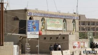 Onlookers gather outside a Shia mosque to inspect the damage after a suicide bomb attack in the al-Qahira district of northern Baghdad