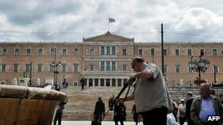 A municipal worker cleans the marble of a fountain in front of the Greek parliament in Athens