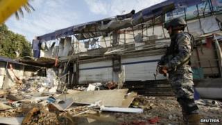 An Iraqi policeman stands guard at the site of a car bomb attack in Baghdad