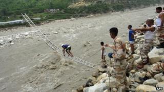 Members of the Indo Tibetan Border Police (ITBP) rescue stranded people with the help of mountaineering ropes and ladders in Uttarkashi in Uttarakhand state