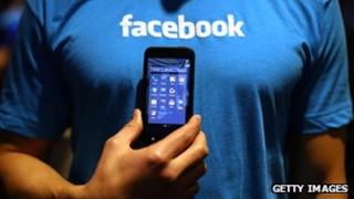 Facebook employee holds a mobile phone