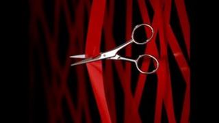 Scissors cutting red tape
