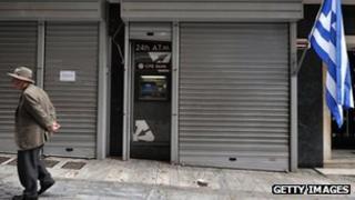 A man in Cyprus outside a closed bank