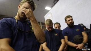 Hotshot firefighters mourn during a moment of silence for the 19 firefighters who perished battling a fast-moving wildland fire at a memorial service, in Prescott, Arizona 1 July 2013