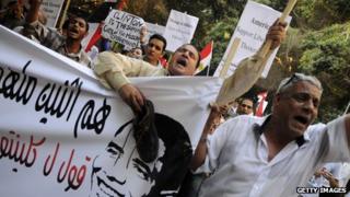Egyptians protest outside US embassy in Cairo on 14 July 2012 as Secretary of State Hiilary Clinton visits the country