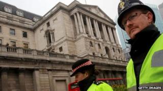 Police walk past the Bank of England