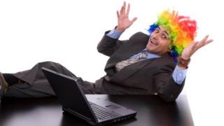 Man in clown wig writes on laptop