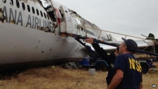 Investigator in Charge Bill English, foreground, and NTSB Chairwoman Deborah Hersman discuss the progress of the investigation into the crash of Asiana Airlines Flight 214 in San Francisco 9 July 2013