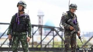 Soldiers hold their weapons at a checkpoint in the troubled southern province of Yala, 28 February 2013