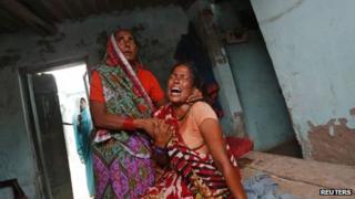 A woman mourns the death of her niece, who died after eating a contaminated meal at a school on Tuesday in Bihar's Chhapra district on 18 July 2013