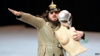 German artist Jonathan Meese gives a Nazi salute while performing 'Generaltanz den Erzschiller' on stage at the National Theatre in Mannheim, western Germany, on 26 June, 2013