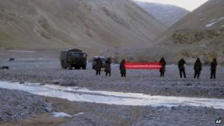 In this May 5, 2013 photo, Chinese troops hold a banner which reads: "You've crossed the border, please go back," in Ladakh, India