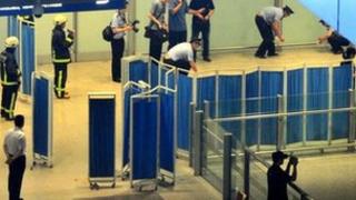 Chinese security personnel investigate the scene where a man in a wheelchair ignited a home-made explosive device at Beijing's international airport terminal 3 on 20 July 2013, injuring himself but no others