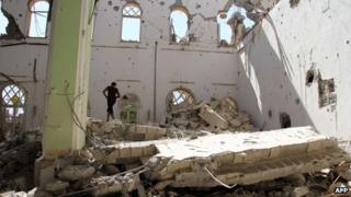 A Syrian man stands amidst the rubble of the Othman mosque, in Syria's eastern town of Deir El-Zor