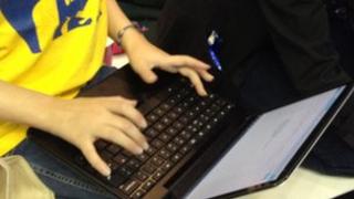 Child typing on laptop close up