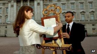 Badar Azim and the Queen's press secretary Ailsa Anderson display the royal birth notice