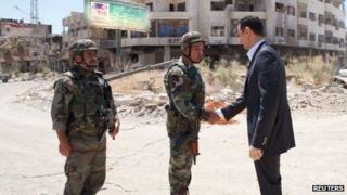 Syrian President Bashar al-Assad greets soldiers in Daraya, outside Damascus, on Thursday in an image released by state news agency Sana