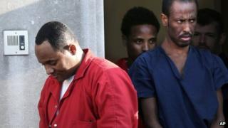 Suspected pirates Shani Nurani Shiekh Abrar, left, and Ahmed Muse Salad, right leave the federal courthouse in Norfolk, Virginia, on 4 June 2013