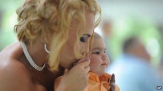 Newlywed Christine Stevenson kisses the hand of her son, Logan Stevenson, 2, after marrying Sean Stevenson