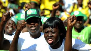 Zanu-PF supporters raise their fists and shout slogans during an election rally in Harare, Zimbabwe, on 28 July 2013