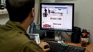 A member of the Israeli Defense Force looks at its Facebook site