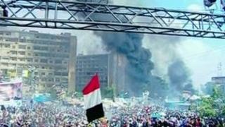Smoke rising behind protesters in Cairo - 14/8/2013
