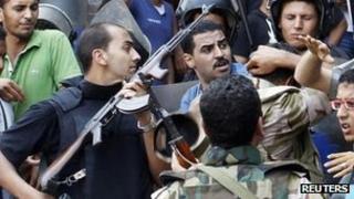 Police and pro-Egyptian government supporters struggle outside al-Fath mosque