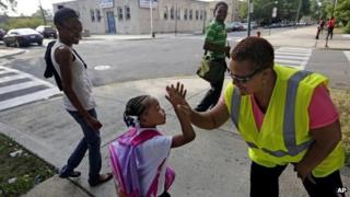 A little girl is greeted by a Safe Passage worker on her way to elementary school in Chicago, Illinois on 26 August 2013