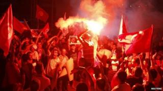 Anti-government protesters hold flares and shout slogans during a demonstration in Tunis August 24, 2013.