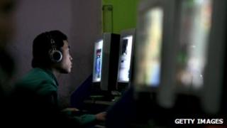 Young Chinese man in an internet cafe