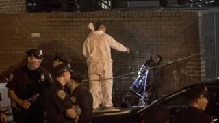 In this 1 September 2013 photo, police investigate the scene where a one-year-old was fatally shot early on Sunday night in the Brownsville area of Brooklyn, New York