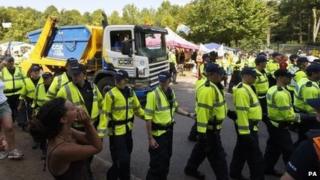 Police escort a lorry arriving at the site