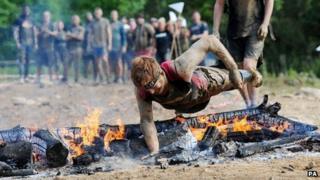 James Simpson diving over burning logs
