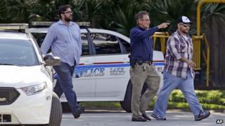 George Zimmerman, far right, is escorted by a police officer, centre, in Lake Mary, Florida after a domestic incident