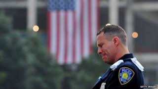Daniel Henry, a Port Authority of New York/New Jersey police officer, pauses during a moment of silence at 9:01 am EDT, at the South reflecting pool of the 9/11 Memorial on 11 September 2013