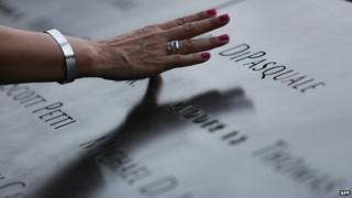 A attendee touches the stone with names of the 9/11 victims at the 9/11 Memorial during ceremonies marking the 12th anniversary of the 9/11 attacks on the World Trade Center in New York 11 September 2013
