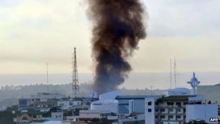 Smoke billows from burning houses as fighting between government troops and Muslim rebels rages in Zamboanga City (16 September 2013)